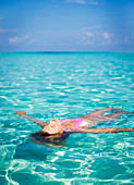 Serene woman floating in tropical ocean