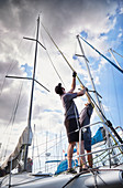 Men adjusting sailing equipment