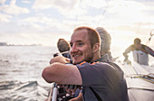 Smiling man sailing on sailboat