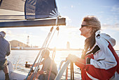 Woman sailing steering sailboat at helm