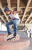 Boy jumping skateboard at skate park