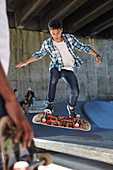 Focused boy flipping skateboard