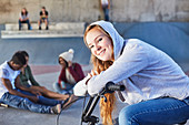 Teenage girl leaning on BMX bicycle