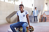 Boy sitting on skateboard