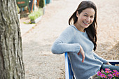 Woman sitting on bench with flowers