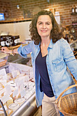 Woman leaning on cheese display case