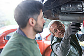 Mechanics repairing car
