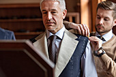 Tailor fitting businessman for suit