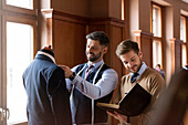 Tailors examining suit and taking notes