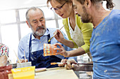 Mature students painting pottery