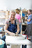 Senior woman using pottery wheel