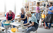 Mature students using pottery wheels