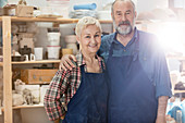 Senior couple wearing aprons