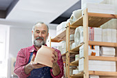 Senior man examining pottery bowl