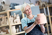 Mature woman holding pottery vase
