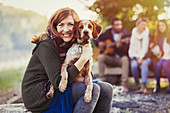 Smiling woman hugging dog at campsite