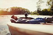 Serene man laying relaxing in canoe