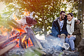 Couple hugging by campfire