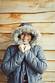 Woman wearing fur hood coat outside cabin