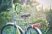 Flowers and garland on bicycle in garden