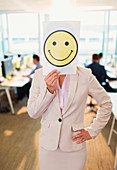 Businesswoman holding smiley face printout