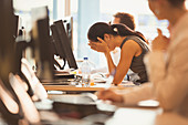 Stressed businesswoman with head in hands