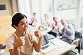Businesswoman and colleagues gesturing thumbs-up
