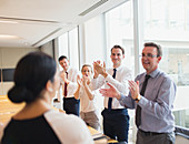 Business people clapping for businesswoman