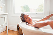 Smiling mature woman enjoying bath