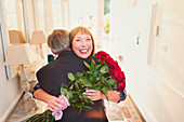 Happy women receiving roses and hugging husband
