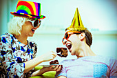Playful couple in party hats and sunglasses