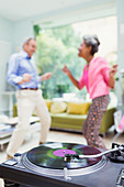 Playful nature couple dancing in living room