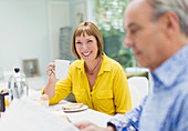 Mature woman drinking coffee at breakfast table