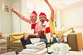 Couple in matching hats and scarves watching TV