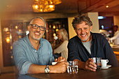 Portrait smiling men drinking coffee and water