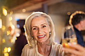 Senior woman toasting white wine glass