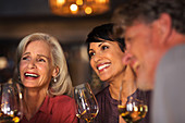 Smiling women drinking white wine at bar
