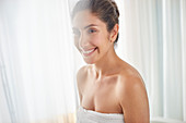 Smiling woman wrapped in towel