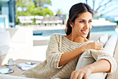 Smiling woman looking away on patio sofa