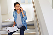 Businesswoman with paperwork talking on cell phone