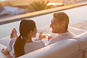 Couple relaxing toasting white wine glasses