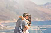 Affectionate couple hugging on balcony