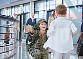 Son running greeting soldier mother at airport