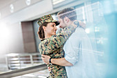 Husband greeting hugging soldier wife at airport