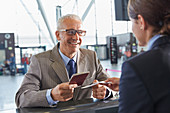 Smiling businessman giving passport