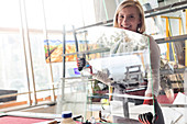 Smiling stained glass artist lifting glass