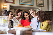 Smiling women dining and talking in restaurant