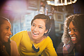 Smiling women laughing and talking in restaurant