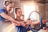 Fitness instructor helping young woman