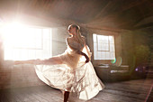 Graceful female dancer dancing in sunny studio